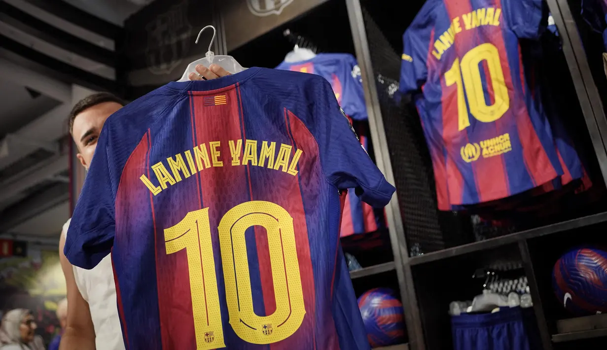 Orang-orang berbelanja jersey baru bernomor punggung 10 dari penyerang Barcelona asal Spanyol, Lamine Yamal, di toko resmi FCB di Barcelona pada 17 Juli 2025. (Manaure QUINTERO/AFP)