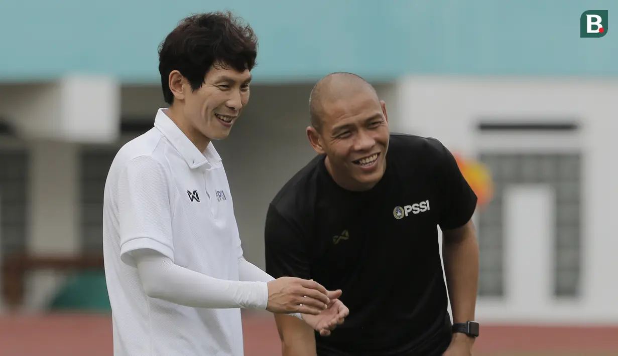 Asisten pelatih Timnas Indonesia, Gong Oh-kyun, berbincang dengan Nova Arianto saat sesi latihan di Stadion Wibawa Mukti, Cikarang, Senin (13/1/2020). Gong Oh-kyun dinyatakan postif terpapar virus corona. (Bola.com/M Iqbal Ichsan)