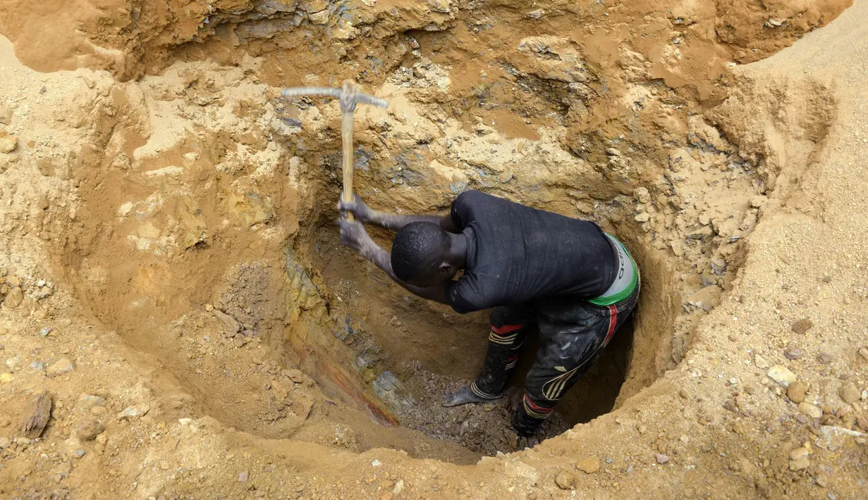 Seorang penambang emas menggali tanah di sebuah situs penambangan di kota Betare Oya, Kamerun (4/4).  (AFP Photo/Reinnier Kaze)