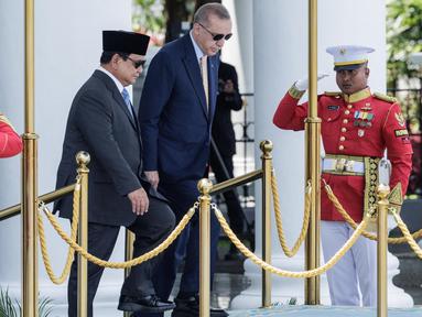 Presiden Indonesia Prabowo Subianto (kiri) dan Presiden Turki Recep Tayyip Erdogan naik ke atas panggung untuk upacara penyambutan di Istana Kepresidenan, Bogor, Jawa Barat, Rabu 12 Februari 2025. (YASUYOSHI CHIBA/AFP)