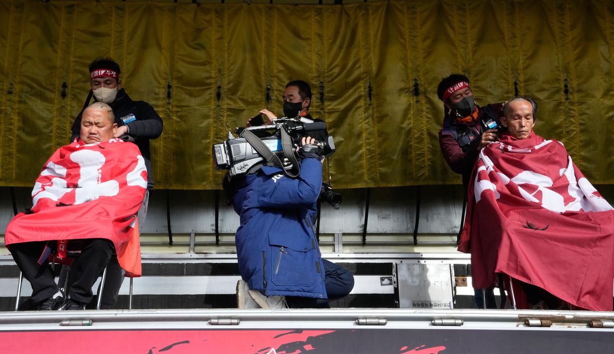 Anggota serikat Solidaritas Pengemudi Truk Kargo mencukur rambut mereka saat unjuk rasa menentang perintah pemerintah untuk kembali bekerja pada pengemudi truk semen di Uiwang, Korea Selatan, Selasa (29/11/2022). Akibat kejadian ini gangguan transportasi kargo mencapai peringatan level tertinggi. (AP Photo/Ahn Young-joon)
