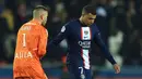 Pemain Paris Saint-Germain (PSG) Kylian Mbappe (kanan) dan kiper Lyon Anthony Lopes berjabat tangan setelah pertandingan sepak bola Liga Prancis di Stadion Parc des Princes, Paris, Prancis, Minggu (2/4/2023). (AP Photo/Aurelien Morissard)