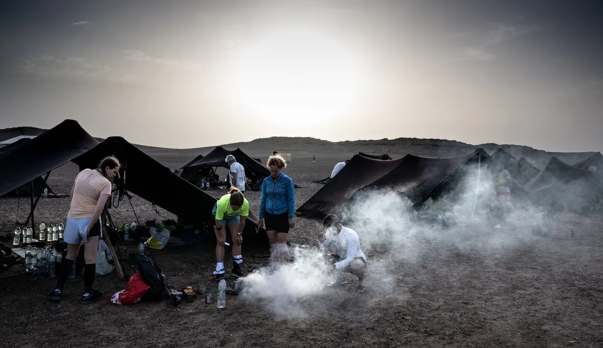 Sejumlah pelari bersiap sebelum stage kedua Marathon des Sables 2023 yang menempuh antara Oued Tijekht hingga Jebel El Otfal di Gurun Sahara, Maroko, 24 April 2023 di Gurun Sahara, Maroko, 24 April 2023. Ajang yang berlangsung dari 21 April hingga 1 Mei 2023 tersebut diikuti oleh 1200 pelari dan akan menempuh 250 km. (AFP/Jean-Philippe Ksiazek)