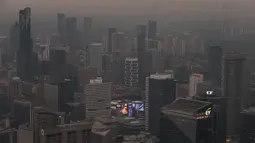 Pemandangan gedung-gedung pusat kota terlihat dari Menara CN saat asap akibat kebakaran hutan di Ontario Utara menyelimuti Toronto dan menyebabkan kualitas udara memburuk, di Toronto, Ontario, Kanada, Kamis, 15 Juli 2026. (AFP/ Cole Burston)