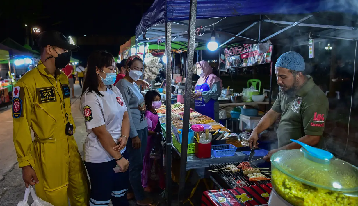 <p>Penjual membuat makanan untuk pembeli  selama bulan suci Ramadhan di pasar malam di provinsi Narathiwat, Thailand selatan (21/4/2022). Penjual makanan jalanan mendirikan kios mereka untuk menjual makanan kepada umat Muslim untuk berbuka puasa. (AFP/Madaree Tohlala)</p>
