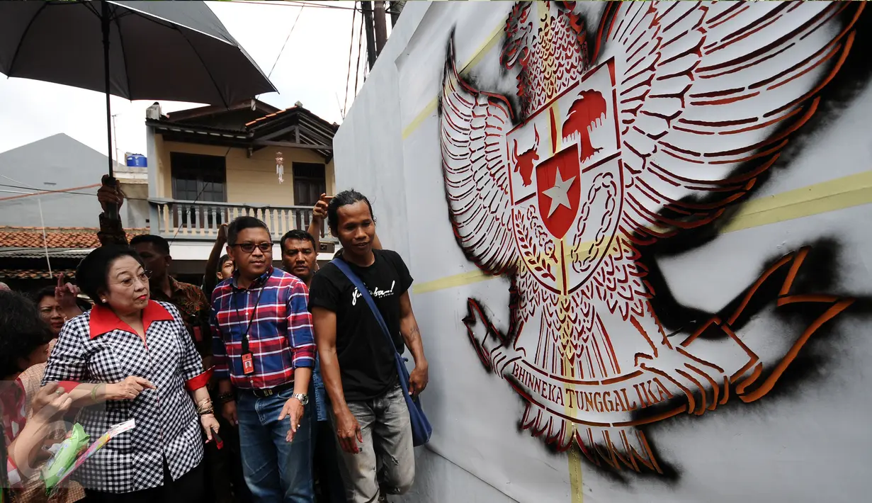 Presiden ke-5 RI yang juga Ketum PDIP, Megawati Soekarnoputri mengamati mural bergambar Garuda Pancasila di dinding TPS tempatnya melakukan pencoblosan Pilkada DKI 2017, di TPS 027 Kebagusan, Jakarta Selatan, Rabu (15/2). (Liputan6.com/Helmi Fithriansyah)