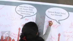 Seorang warga melakukan tanda tangan di bentangan sapanduk panjang di Bundaran HI, Jakarta, Minggu (16/4). Ratusan tanda tangan tersebut di bentuk untuk mendukung pilkada DKI Jakarta yang damai dan tidak golput. (Liputan6.com/Angga Yuniar)