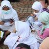 Anak-anak membaca Al-Quran sambil menunggu waktu berbuka puasa di halaman Masjid Raya Jakarta Islamic Center, Jakarta Utara, Senin (18/4/2022). Acara ngabuburit sambil khataman Al-Quran ini merupakan rangkaian acara menyambut 17 Ramadhan atau malam Nuzulul Quran. (Liputan6.com/Herman Zakharia)