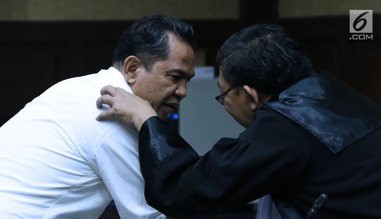 Bupati Hulu Sungai Tengah (HST) nonaktif, Abdul Latifberbincang dengan penasehat hukumnya saatsidang tuntutan di Pengadilan Tipikor, Jakarta, Senin (6/8). JPU KPK menyakini, Abdul Latif menerima suap Rp 3,6 miliar. (Liputan6.com/Helmi Fithriansyah)