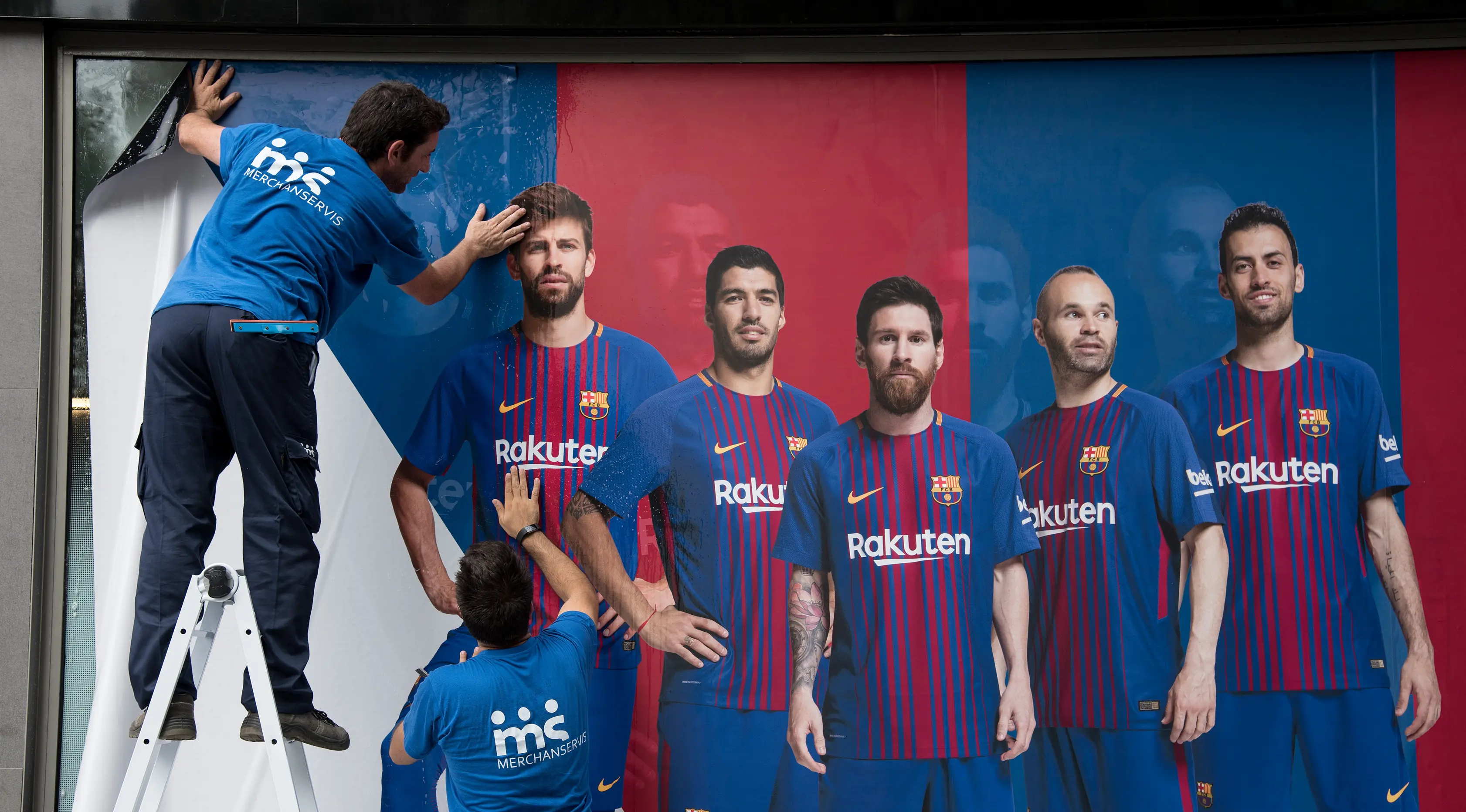 Pekerja memasang poster baru di luar Stadion Camp Nou di Barcelona (2/8). Barcelona mengakui kekalahan dalam meyakinkan penyerang Brasil tersebut untuk tinggal di Camp Nou. (AFP Photo/Josep Lago)