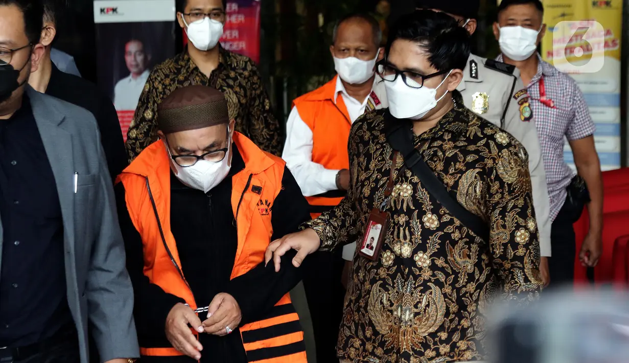 Petugas menggiring dua tersangka dugaan korupsi pekerjaan pembangunan Stadion Mandala Krida Daerah Istimewa Yogyakarta menuju mobil tahanan di Gedung KPK, Jakarta, Kamis (21/7/2022). KPK menahan Direktur Utama PT Arsigraphi, Sugiharto (kedua kiri depan) dan Kabid Pendidikan Khusus Dinas Pendidikan, Pemuda dan Olahraga DIY, Edy Wahyudi. (Liputan6.com/Helmi Fithriansyah)