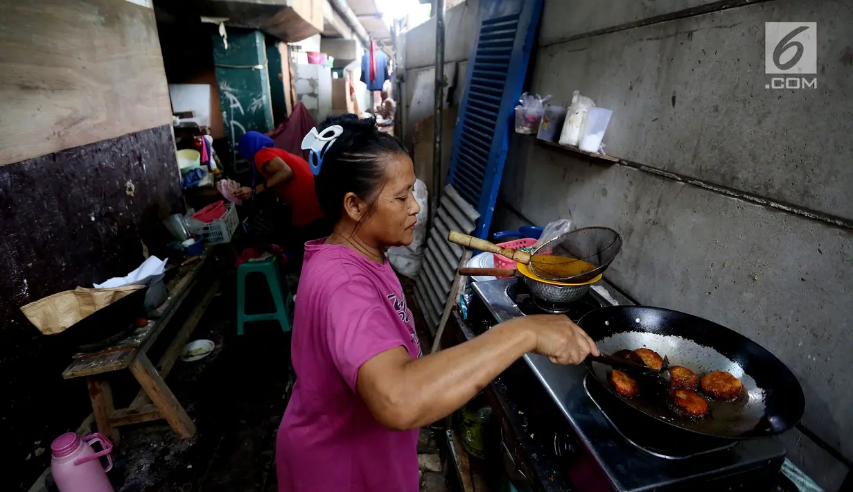 Warga memasak di kawasanan pemukiman kumuh di kolong Tol Pluit, Jakarta, Kamis (14/12). Kolong Tol Pluit ini menjadi pemukiman bagi warga berpenghasilan rendah. (Liputan6.com/JohanTallo)