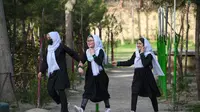 Anak perempuan tiba setelah sekolah mereka dibuka kembali di Kabul, Rabu (23/3/2022). Pembukaan kembali sekolah menengah untuk anak perempuan di seluruh Afghanistan memicu kegembiraan dan ketakutan puluhan ribu siswa yang kehilangan pendidikan sejak Taliban kembali berkuasa. (Ahmad SAHEL ARMAN/AFP)