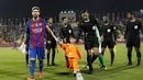 Murtaza Ahmadi mendampingi Lionel Messi memasuki lapangan sebelum laga persahabatan melawan Al Ahli di Doha, Selasa (13/12/2016). (AFP)