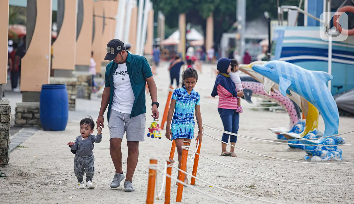 Wisatawan berjalan di Pantai Ancol, Jakarta, Sabtu (25/12/2021). Libur Natal dimanfaatkan masyarakat berwisata ke Pantai Ancol, Kawasan Pantai Ancol merupakan salah satu objek wisata yang kerap menjadi tujuan wisatawan saat mengisi waktu liburan. (Liputan6.com/Faizal Fanani)