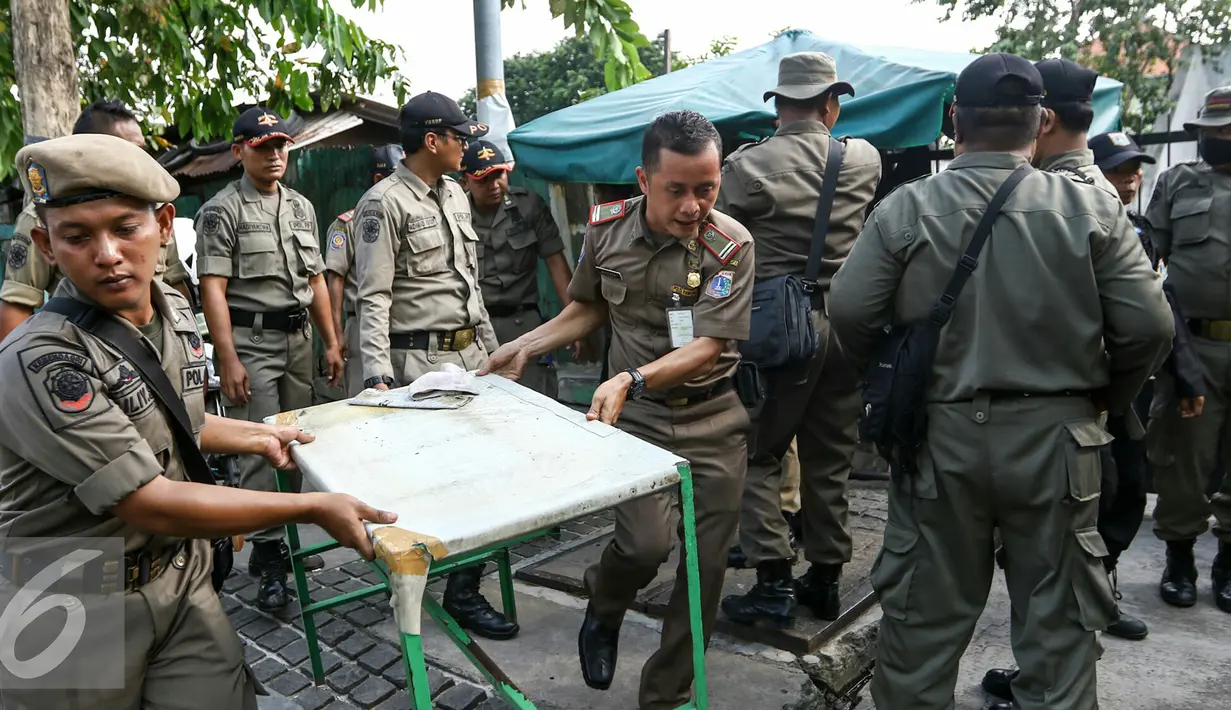 Petugas Satpol PP mengakut lapak pedagang ke atas mobil truk kdi kawasan Senen, Jakarta, Selasa (29/3/2016). Penertiban dilakukan karena lapak PKL yang berada di atas trotoar mengganggu pejalan kaki. (Liputan6.com/Yoppy Renato)