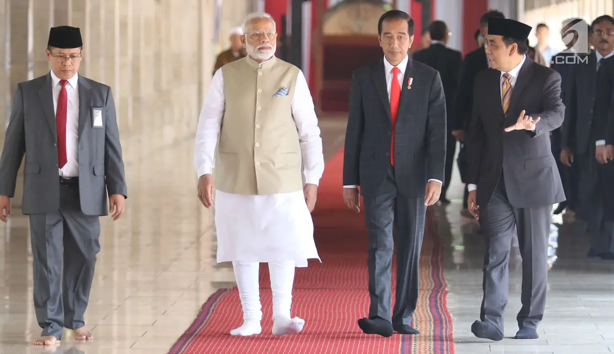 Presiden Joko Widodo dan PM India Narendra Modi berjalan di Masjid Istiqlal, Jakarta, Rabu (30/5). Kunjungan membahas kerja sama antara kedua negara serta untuk menyambut 70 tahun hubungan diplomatik Indonesia-India. (Liputan6.com/Angga Yuniar)