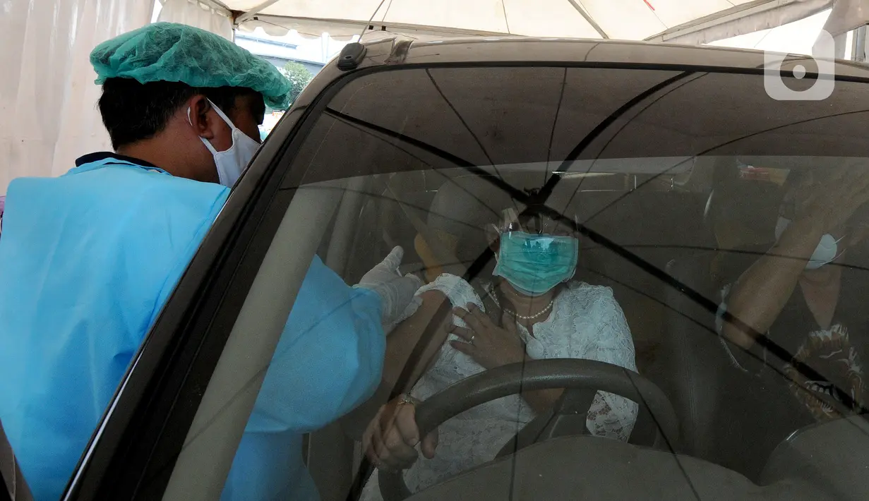 Paramedis menyuntikkan vaksin COVID-19 kepada warga saat vaksinasi secara drive-thru di ICE BSD, Tangerang, Banten, Sabtu (13/3/2021). Vaksinasi ini diselenggarakan atas kerja sama Pemerintah Kota Tangsel dan perusahaan jasa angkutan online. (merdeka.com/Arie Basuki)
