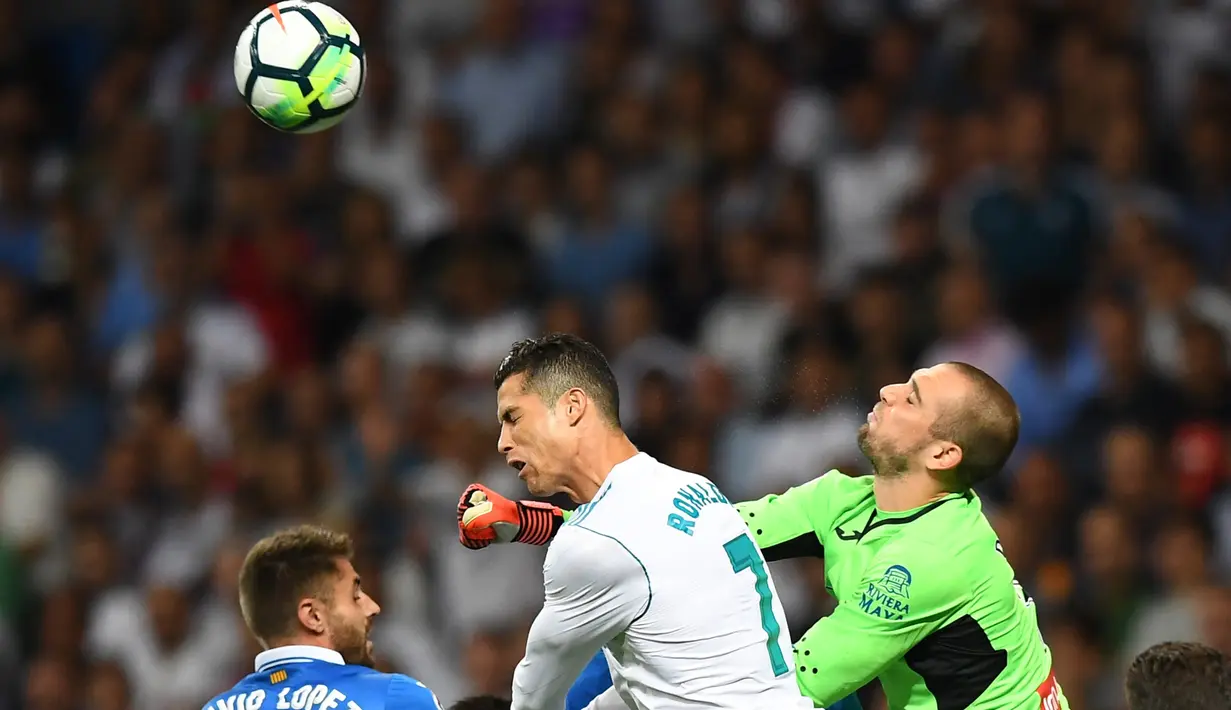 Kiper Espanyol, Pau Lopez (kanan) menghalau bola dari sundulan Cristiano Ronaldo pada lanjutan La Liga Santander di Santiago Bernabeu stadium, Madrid, (01/10/2017). Real Madrid menang 2-0. (AFP/Gabriel Bouys)