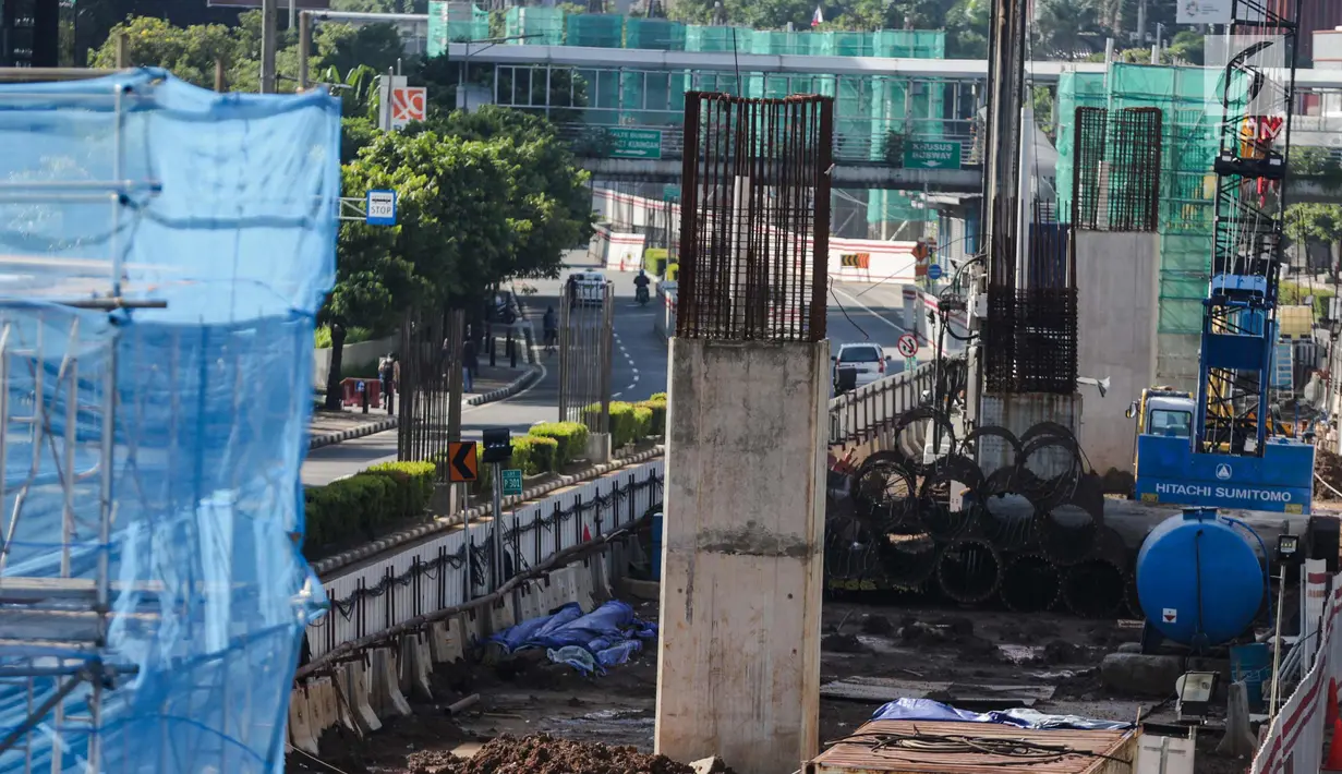 Kendaraan melintas di samping proyek LRT di kawasan Kuningan, Jakarta, Senin (1/1). Sejumlah proyek infrastruktur lain di Ibukota, seperti proyek LRT tampak sepi aktifitas pengerjaan dikarenakan Libur Tahun Baru. (Liputan6.com/Faizal Fanani)