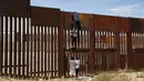 Sejumlah pemuda Meksiko berusaha memanjat tembok besi perbatasan antara Meksiko dan Amerika Serikat di negara bagian Chihuahua, Meksiko (6/4). Aksi nekat ini dapat ditindak tegas oleh pihak keamanan Amerika Serikat. (AFP/Herika Matinez)