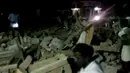 Sejumlah orang berdiri di puing-puing setelah kebakaran yang melanda sebuah kuil di Kollam, India Selatan, Minggu (10/4). Setidaknya 75 orang tewas dan lebih dari 200 terluka akibat kebakaran yang dipicu dari pesta kembang api tersebut. (REUTERS/ANI)