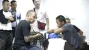 Pelatih Craig Christian sedang memasang perban pada tangan Daud Yordan diruang ganti sebelum bertanding melawan Yoshitaka Kato di Balai Sarbini, Jakarta, Jumat (5/2/2016). (Bola.com/Nicklas Hanoatubun)