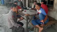 Personel Polres Kampar berbincang dengan warga untuk mensosialisasikan Pemilu damai. (Liputan6.com/M Syukur)