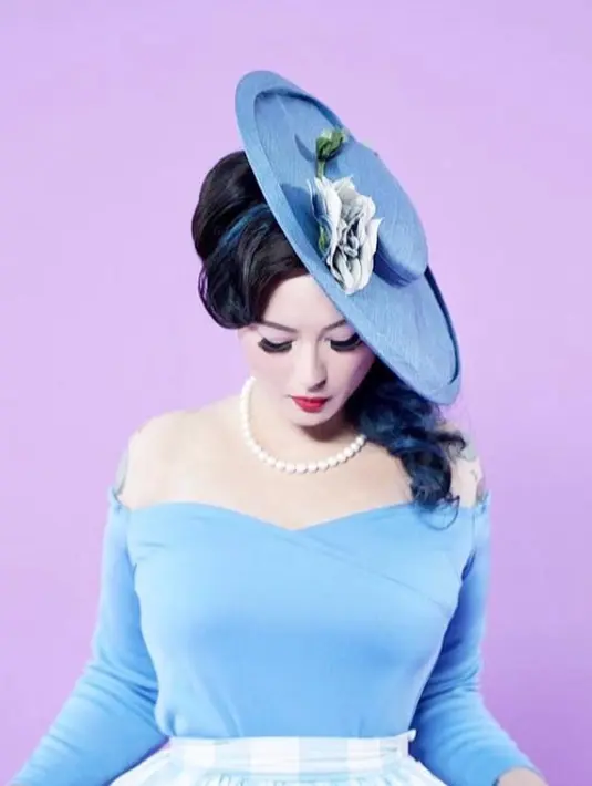 Padukan off shoulder dress warna biru dengan plaid skirt warna senada. Lengkapi penampilanmu dengan fascinator seperti look Claudia ini. (Instagram/miss_adinda_mae).