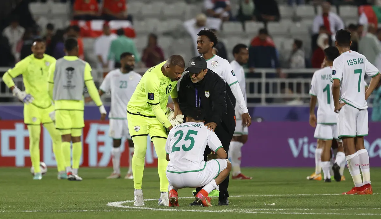 Kiper cadangan Timnas Oman, Faiyz Al Rusheidi dan seorang ofisial tim berusaha menghibur Abdullah Al Mushaifri (bawah) setelah bermain imbang 1-1 menghadapi Kirgistan pada laga ketiga Grup F Piala Asia 2023 di Abdullah bin Khalifa Stadium, Doha, Qatar, Kamis (25/1/2024) yang membuat Oman dan Kirgistan gagal lolos ke babak 16 besar. (AFP/Karim Jaafar)