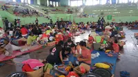 Puluhan remaja Palang Merah Indonesia (PMI) tengah mendata administrasi para pengungsi di dalam GOR Swecapura. Mereka dikerahkan BPBD Klungkung sebagai langkah pengecekan awal pengungsi Gunung Agung. (Liputan6.com/Nanda Perdana Putra)