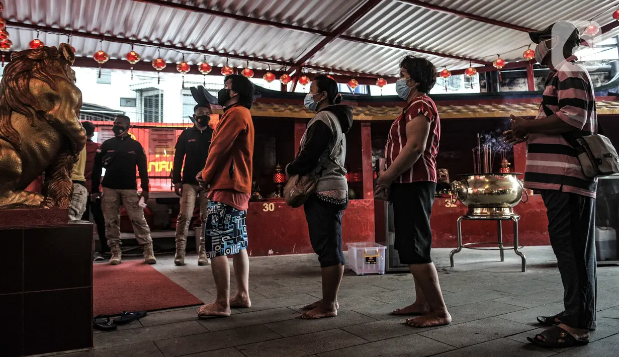 Warga keturunan Tionghoa antre untuk melaksanakan sembahyang malam Tahun Baru Imlek 2572 di klenteng kawasan Petak Sembilan, Glodok, Jakarta, Kamis (11/2/2021). Pihak klenteng membatasi jumlah umat yang ingin sembahyang maksimal 50 persen. (merdeka.com/Iqbal S. Nugroho)