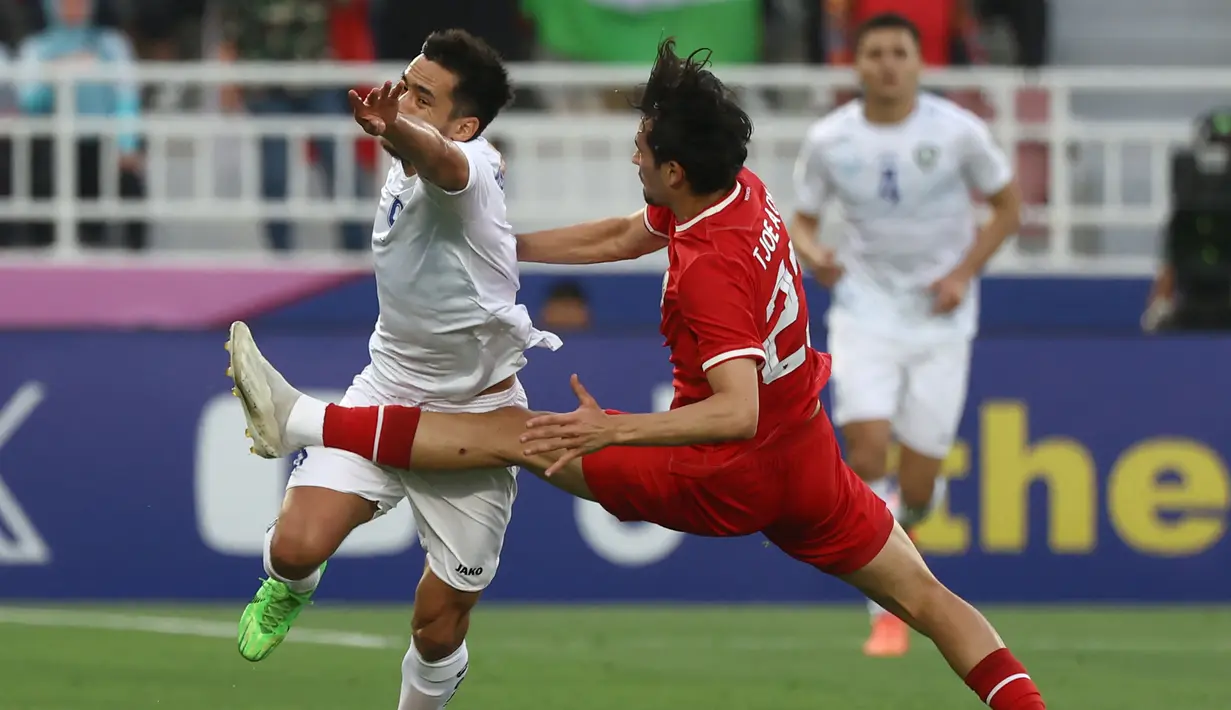 <p>Pemain Timnas Indonesia U-23, Nathan Tjoe-A-On (kanan) berusaha menghadang laju pemain Uzbekistan U-23, Ulugbek Khoshimov pada laga semifinal Piala Asia U-23 2024 di Abdullah bin Khalifa Stadium, Doha, Qatar, Senin (29/4/2024). (AFP/Karim Jaafar)</p>