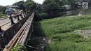 Warga dan pengendara melintasi jembatan di sisi Situ Pengarengan, Kota Depok, Jawa Barat, Kamis (18/4). Tumpukan sampah dan tanaman eceng gondok terlihat menumpuk menutupi permukan air Situ Pengarengan. (Liputan6.com/Helmi Fithriansyah)