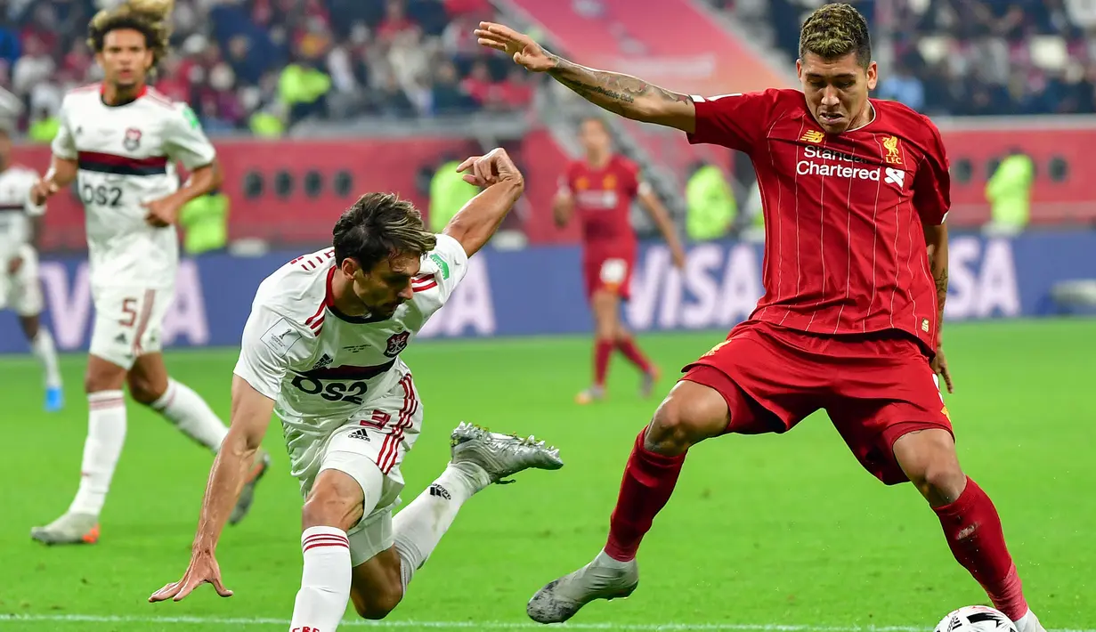 Gelandang Liverpool, Roberto Firmino, berusaha melewati bek flamengo, Rodrigo Caio, pada laga Piala Dunia Antarklub 2019 di Stadion Internasional Khalifa, Doha, Minggu (21/12). Liverpool menang 1-0 atas Flamengo. (AFP/Giuseppe Cacace)