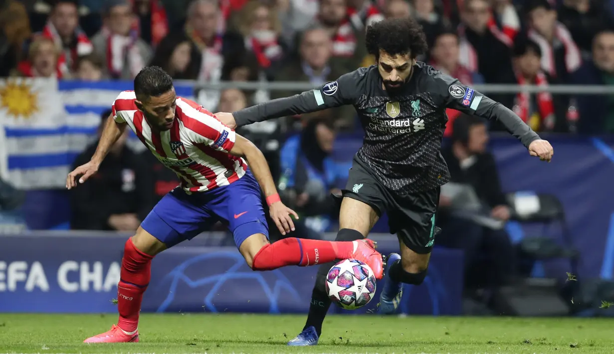 Penyerang Liverpool, Mohamed Salah berusaha melewati bek Atletico Madrid, Renan Lodi pada pertandingan leg pertama babak 16 Liga Champions di stadion Wanda Metropolitano di Madrid, Spanyol, Selasa (18/2/2020). Atletico Madrid menang tipis atas Liverpool 1-0. (AP Photo/Manu Fernandez)