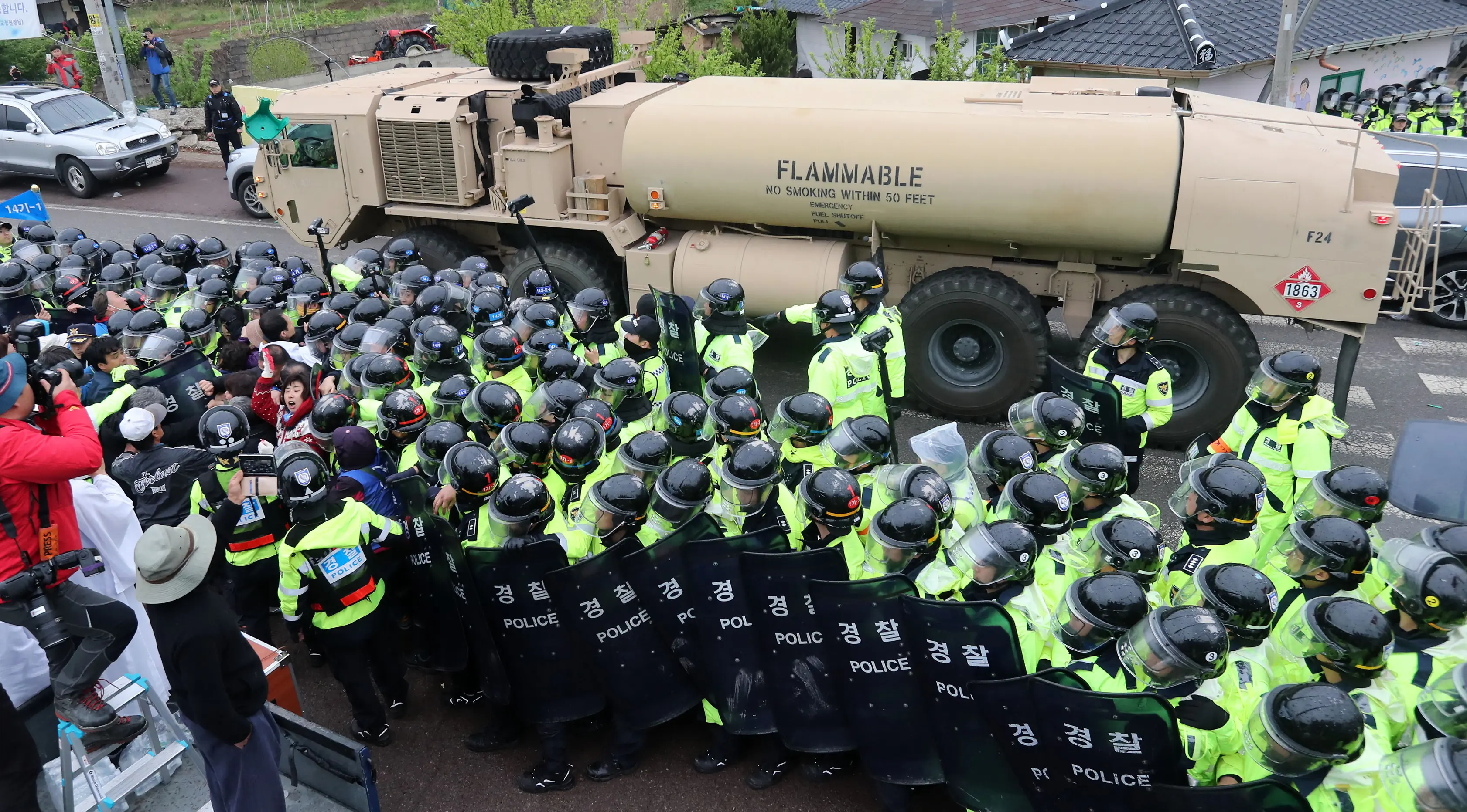 Polisi setempat berjaga saat kendaraan yang membawa peralatan rudal THAAD AS melintas di Seongju, Korsel (26/4). Penempatan perangkat perang itu dilakukan menyusul meningkatnya ancaman dari Korea Utara. (AFP Photo/Yonhap)