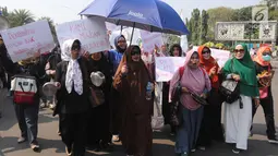 Sejumlah ibu-ibu yang tergabung dalam Barisan Emak-Emak Militan Indonesia menggelar aksi di seberang Istana Merdeka, Jakarta, Rabu (18/7). Dalam aksinya, emak-emak ini  membawa peralatan memasak seperti penggorengan dan panci. (Liputan6.com/Arya Manggala)