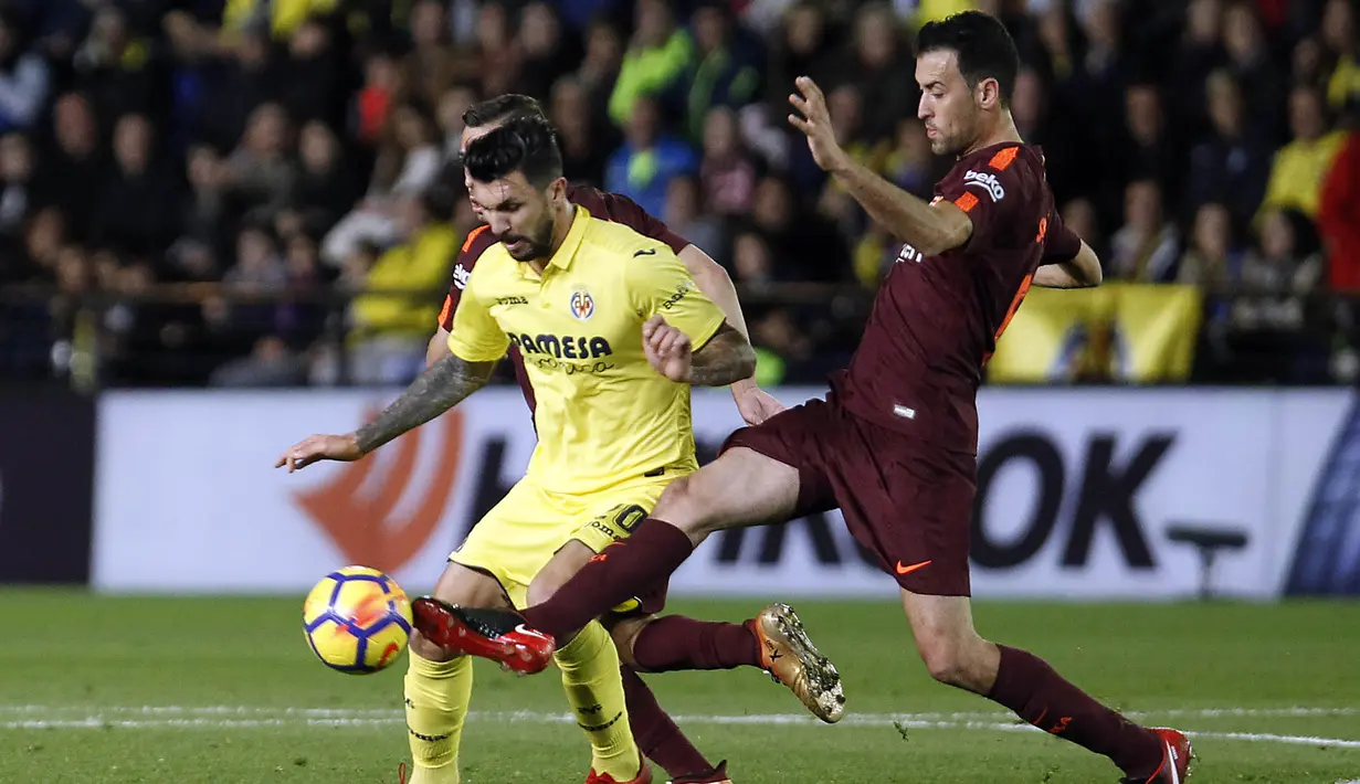 Gelandang Barcelona, Sergio Busquets, berusaha merebut bola dari gelandang Villarreal, Roberto Soriano, pada laga La Liga, di Stadion De La Cerramica, Minggu (10/12/2017). Barcelona menang 2-0 atas Villarreal. (AP/Alberto Saiz)
