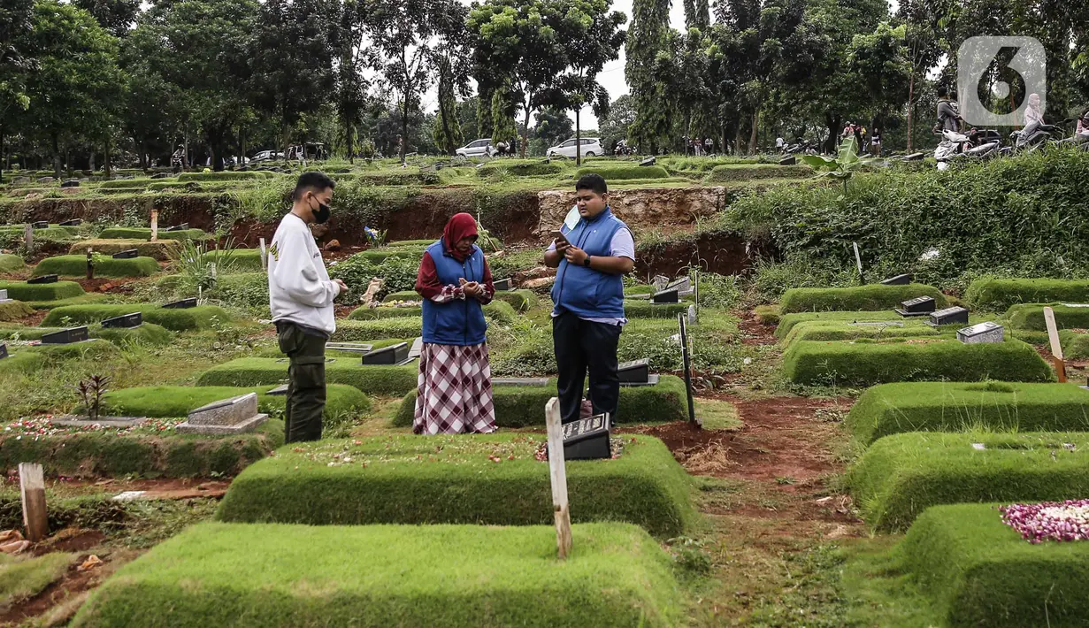 Umat Muslim berdoa di makam keluarga saat  melakukan ziarah di Tempat Pemakaman Umum (TPU) Pondok Ranggon, Jakarta, Minggu (04/04/21). Meskipun di tengah pandemi Covid-19 warga tetap melakukan tradisi ziarah kubur menjelang bulan Ramadan. (Liputan6.com/Faizal Fanani)