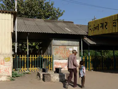 Foto pada 20 Maret 2014 menunjukkan pejalan kaki melintas di depan bekas kedai teh milik ayah PM India, Narendra Modi di stasiun kereta Vadnagar. Kedai teh itu akan dijadikan objek wisata untuk memperlihatkan perjuangan masa kecil Modi. (SAM PANTHAKY/AFP)