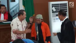 Korban ledakan bom di Jalan MH Thamrin pada Januari 2016, Ipda Denny Mahieu menyapa terdakwa Aman Abdurrahman di PN Jakarta Selatan, Jumat (23/2). Aman didakwa menggerakkan orang melakukan berbagai aksi terorisme. (Liputan6.com/Ady Anugrahadi)