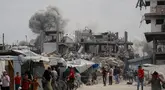 Warga Palestina berlarian menyelamatkan diri saat serangan Israel menghantam rumah keluarga Hmeid di Jabalia, Jalur Gaza Utara, 15 Mei 2025. (Bashar TALEB/AFP)
