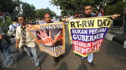 Massa dari Forum RT/RW membentangkan spanduk penolakan terhadap Gubernur DKI, Basuki Tjahaja Purnama di Balai Kota DKI Jakarta, Jumat (16/9). Mereka melakukan aksi damai dalam bentuk long march serta orasi kebebasan. (Liputan6.com/Immanuel Antonius)