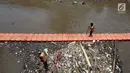 Petugas kebersihan Pemprov DKI mencoba mengurai sampah di Pintu air Manggarai, Jakarta, Senin (2/10). Dinas Kebersihan DKI mengangkat sampah seberat 90-220 ton/hari dari badan air di sungai, waduk, setu dan danau di Ibu Kota. (Liputan6.com/Johan Tallo)