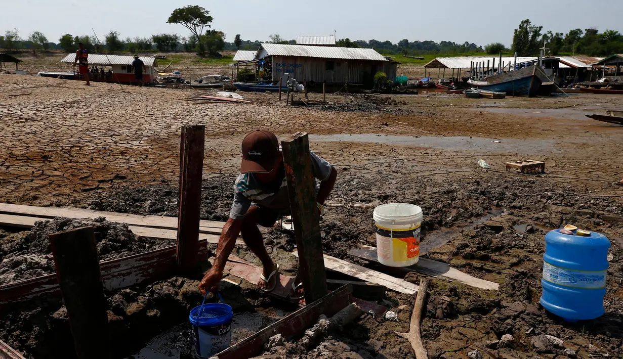 Raimundo Silva do Carmo, 67 tahun, mengambil air untuk diminum dari sumur yang digali di dasar danau Puraquequara yang kering di tengah kekeringan parah, di Manaus, negara bagian Amazonas, Brasil, Kamis, 5 Oktober 2023. (AP Photo/Edmar Barros)