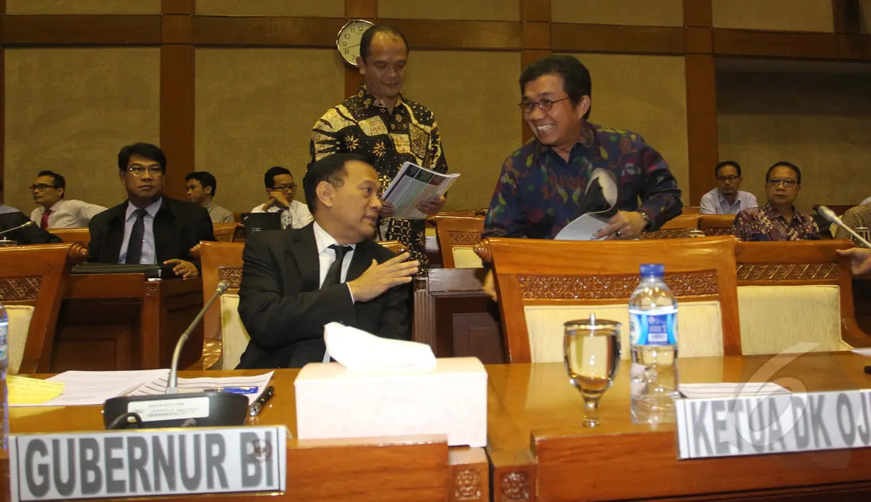 Gubernur BI Agus Martowardojo (kiri) berbincang dengan Kepala OJK, Muliaman D. Hadad sebelum memulai raker dengan Komisi XI DPR RI dan empat lembaga keuangan di Jakarta, Rabu (25/3/2015). (Liputan6.com/Andrian M Tunay)