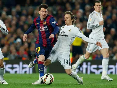 Penyerang Barcelona, Lionel Messi (kedua dari kiri) berusaha melewati dua pemain Real Madrid pada laga Liga Spanyol di Stadion Nou Camp, Senin (23/3/2015). Barcelona Menang 2-1 atas Real Madrid. (Reuters/Albert Gea)