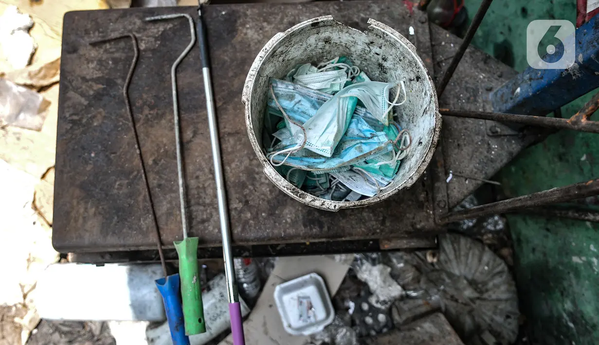 Alat pemilah dan ember yang digunakan petugas terlihat di Dipo Sampah Kecamatan Pademangan, Ancol, Jakarta, Rabu (24/2/2021). Pemilahan mulai dari memilah masker, menyemprotkan disinfektan kemudian dibungkus dan disimpan di tempat khusus sebelum dibuang pihak ketiga. (merdeka.com/Iqbal S. Nugroho)