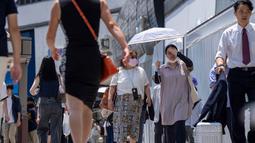 Suhu diperkirakan akan melampaui 41 derajat Celsius di beberapa area pedalaman wilayah Kanto. Tampak dalam foto, orang-orang berjalan di trotoar di Tokyo pada 5 Agustus 2025. (Kazuhiro NOGI/AFP)